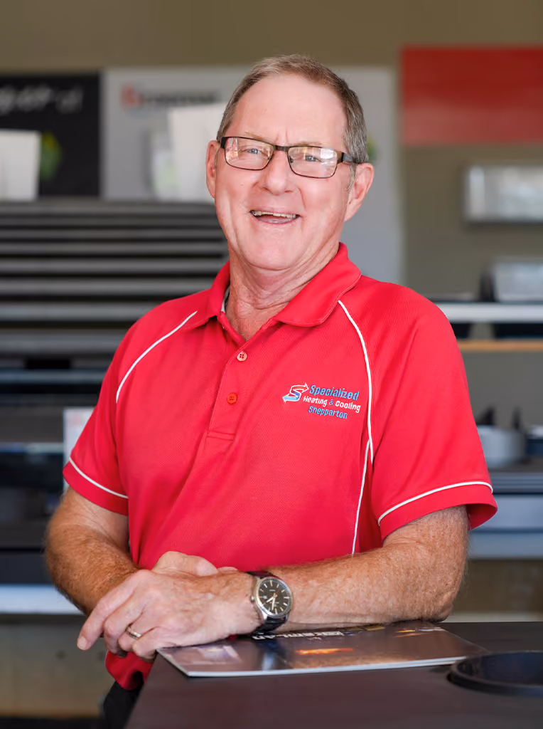 Smiling man wearing glasses and red Specialized Heating & Cooling Shepparton polo shirt.