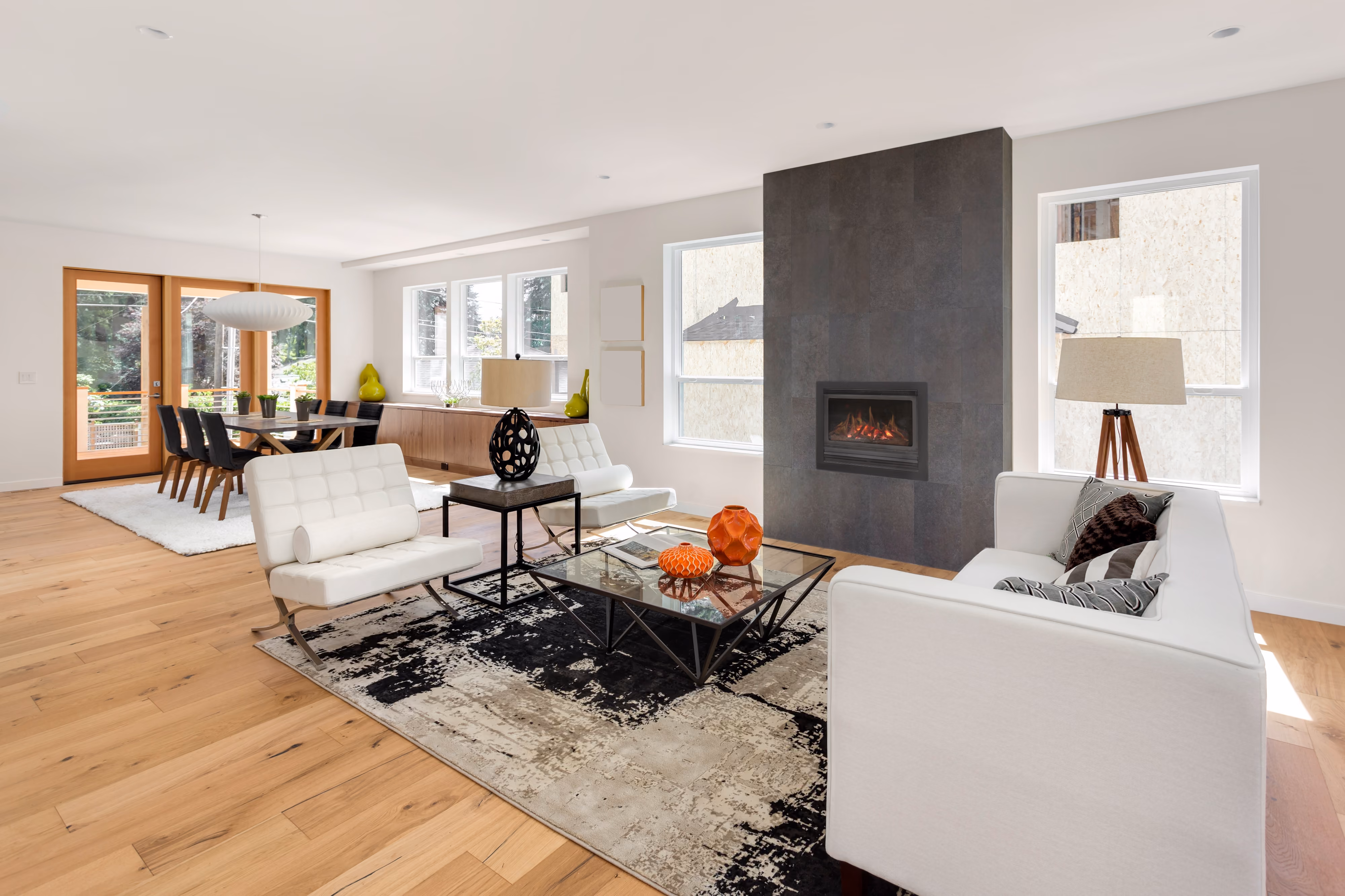Modern living room with stone walls, wood stairs, beige sofa, TV, and wall-mounted air conditioner.