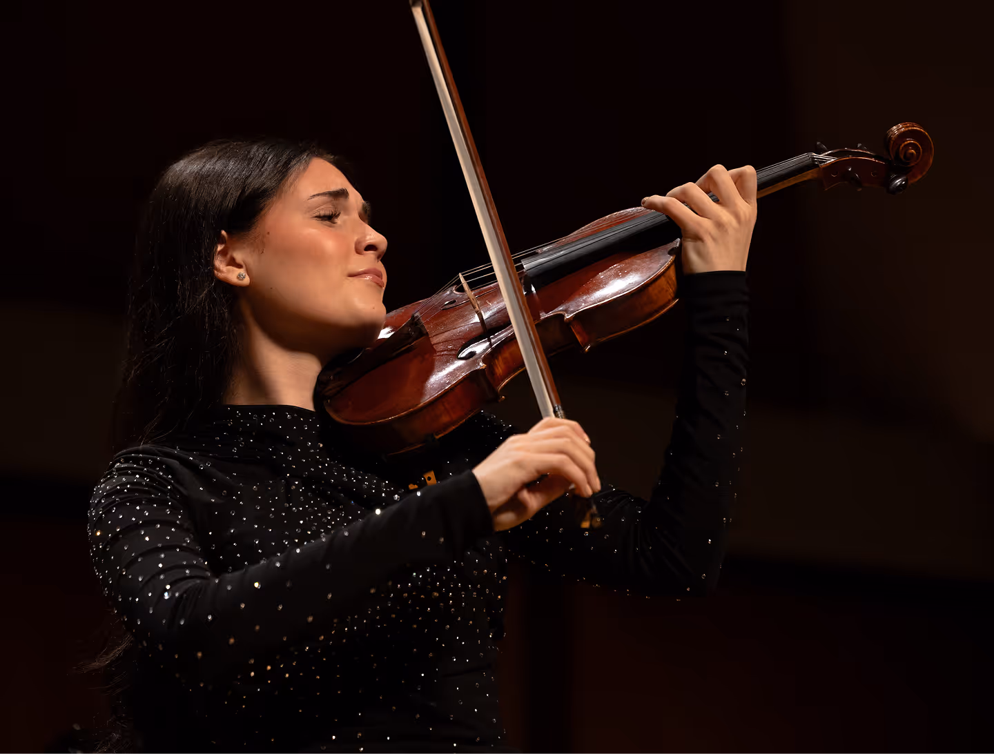 Nesya performing on violin on stage