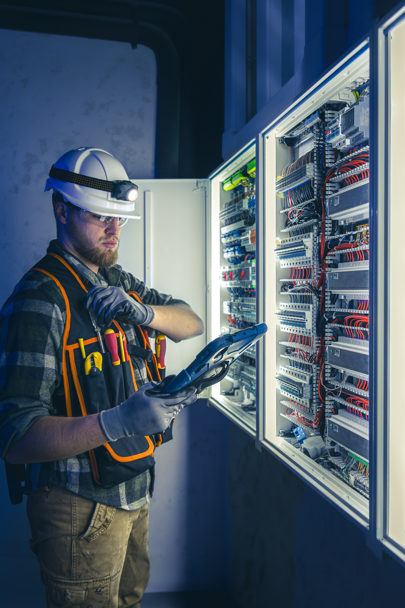 Electrical contractor reviewing job costs and profit on a tablet