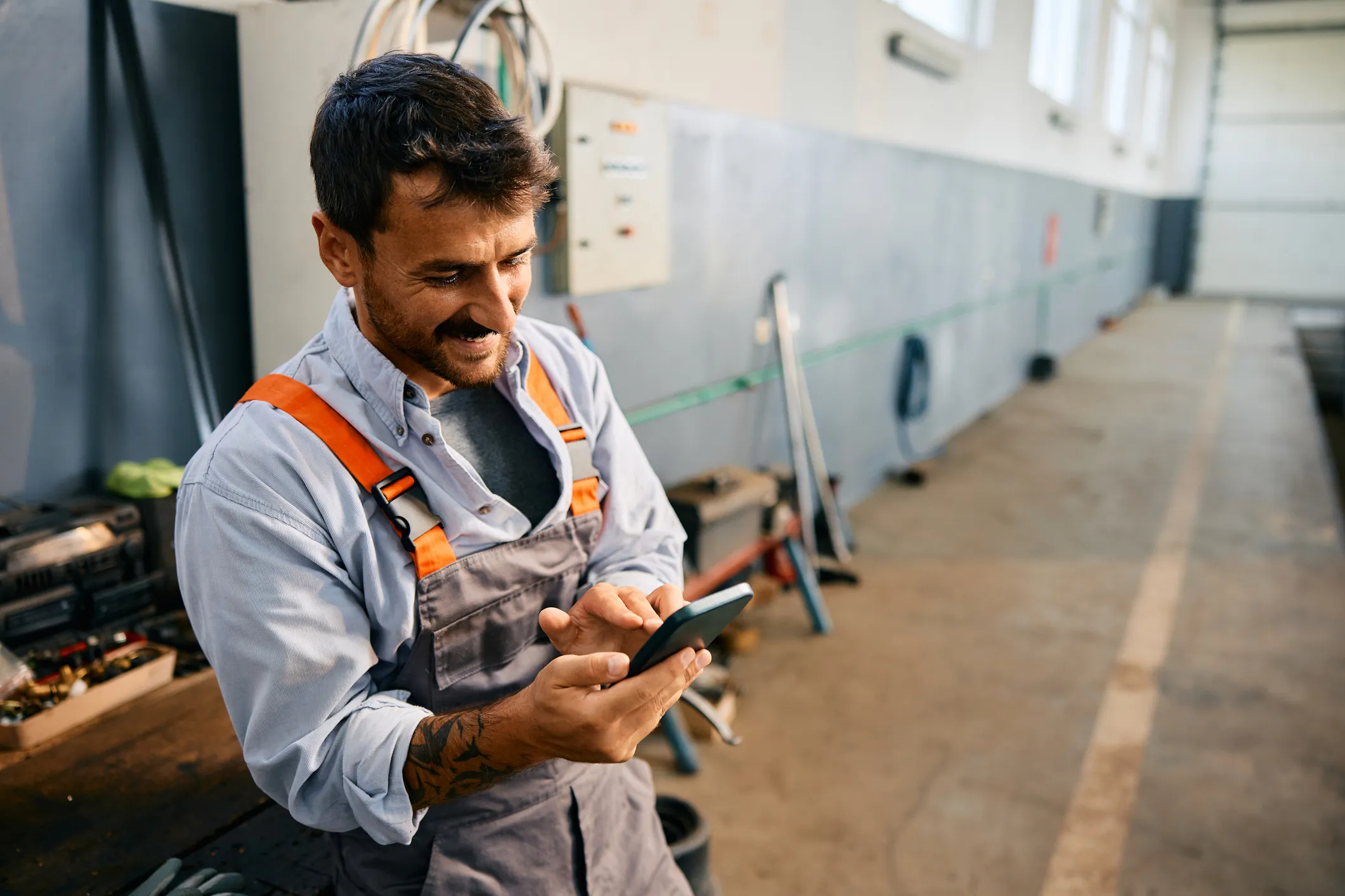 Electrical contractor checking his phone in the shop