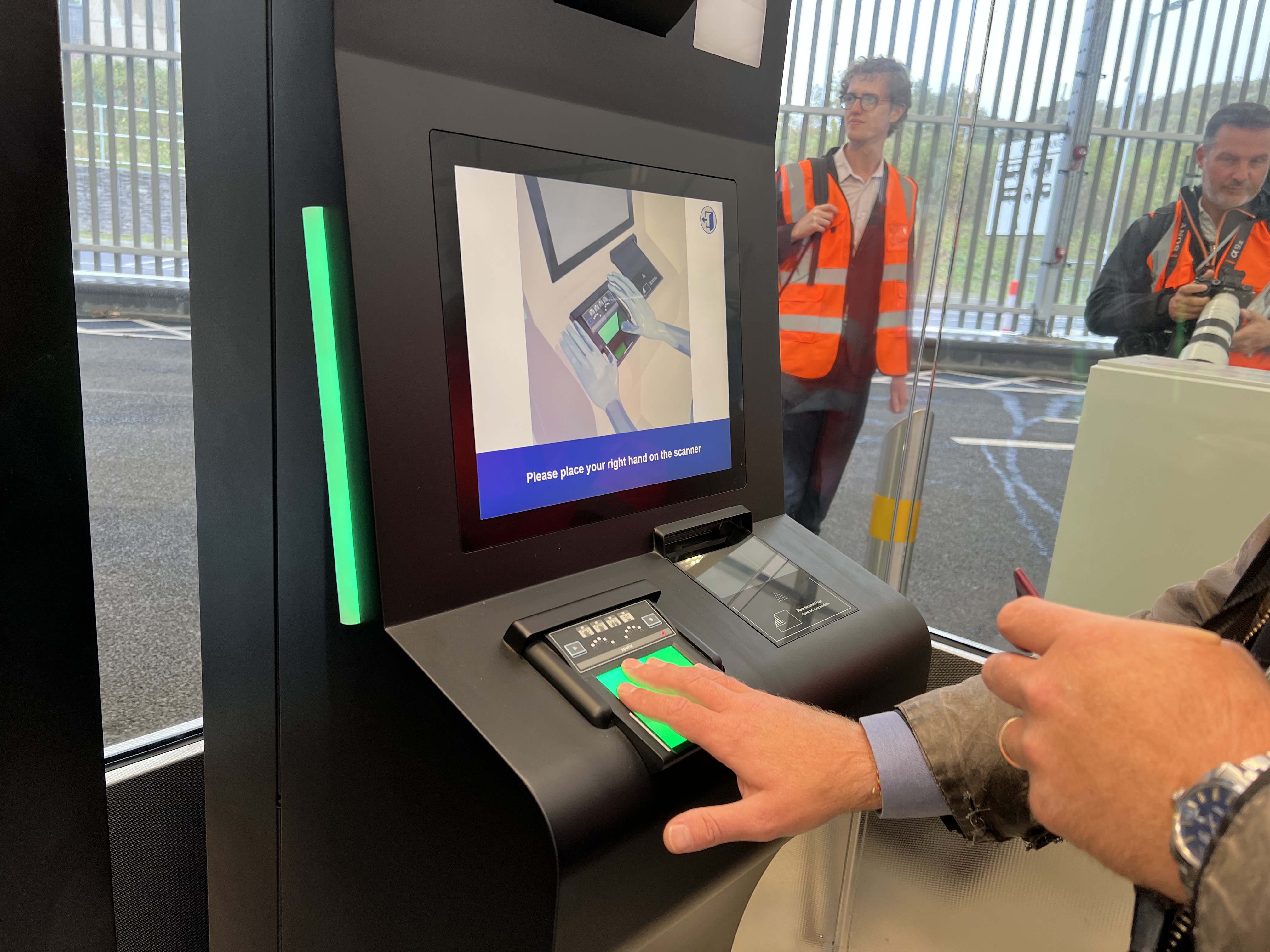 Man using automated e-gate for border control with a hand scanner