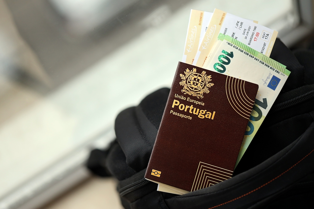 Portuguese passport, Euro cash, and boarding passes tucked into a black travel bag