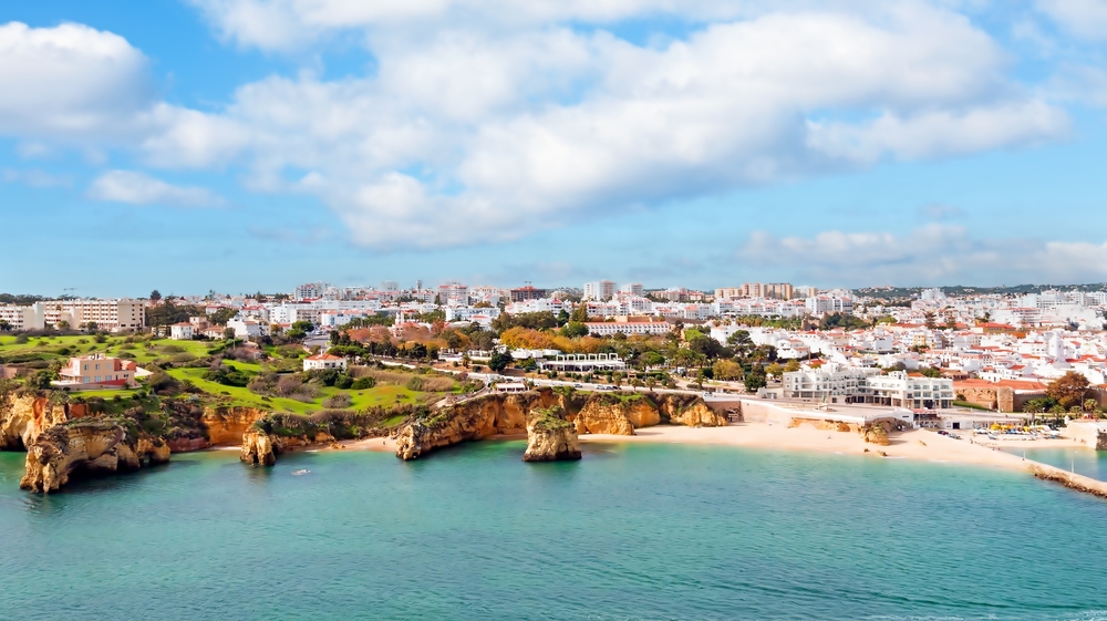 Scenic coastal town in the Algarve with golden cliffs and turquoise Atlantic Ocean water