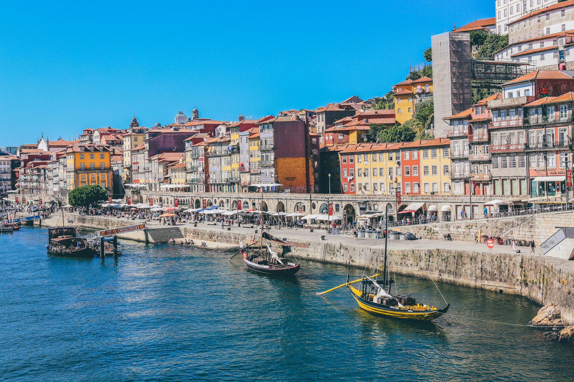 Colorful Ribeira district houses and traditional Rabelo boats on the Douro River in Porto