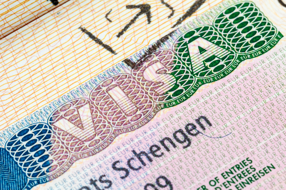 Close-up of a colorful Schengen visa sticker featuring ornate security patterns and text