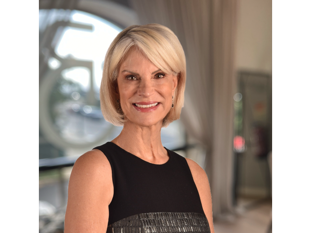 Blonde woman with short bob hairstyle wearing a black sleeveless dress