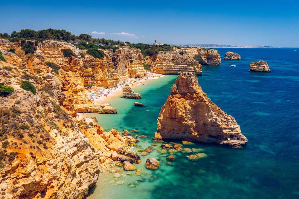 Panorama of Praia da Marinha, with golden limestone cliffs and turquoise water