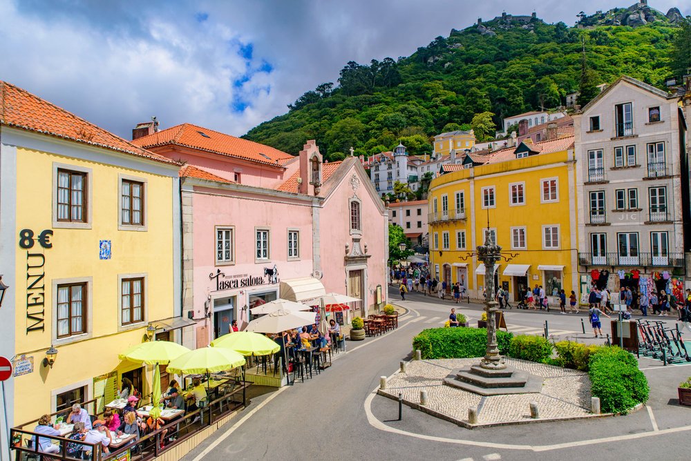 Vibrant town square in Sintra, Portugal, with colorful buildings and a mountain backdrop