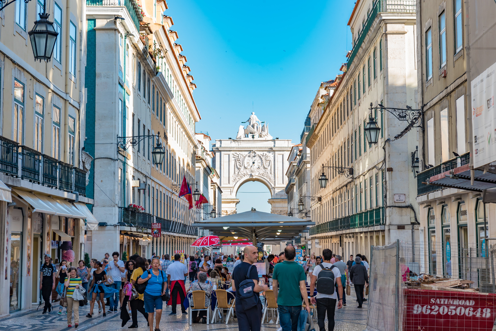Busy pedestrian street in Lisbon leading towards the historic Arco da Rua Augusta archway