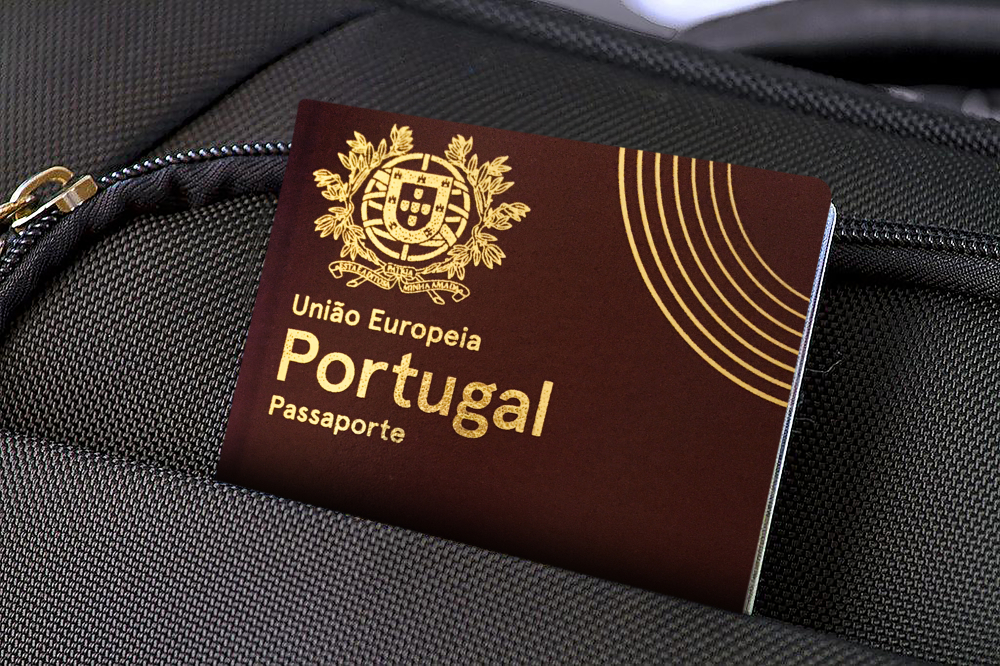 A burgundy red Portuguese passport tucked into pocket of dark grey luggage