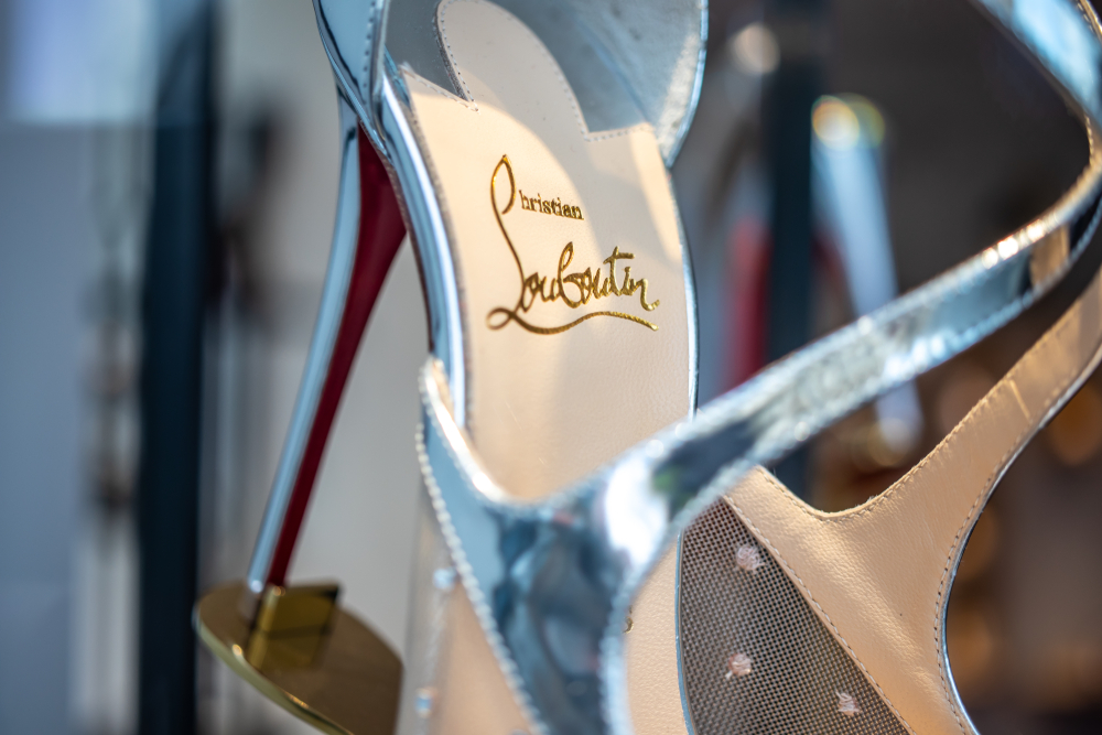 Christian Louboutin silver heels with signature red sole and gold script