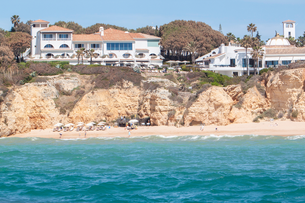 Luxurious seaside resort built on golden cliffs overlooking a sandy beach and blue ocean