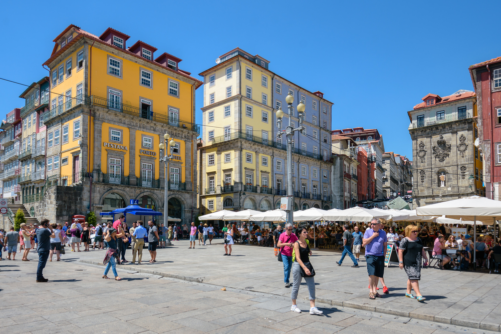 Colourful Ribeira embankment in Porto crowded with tourists