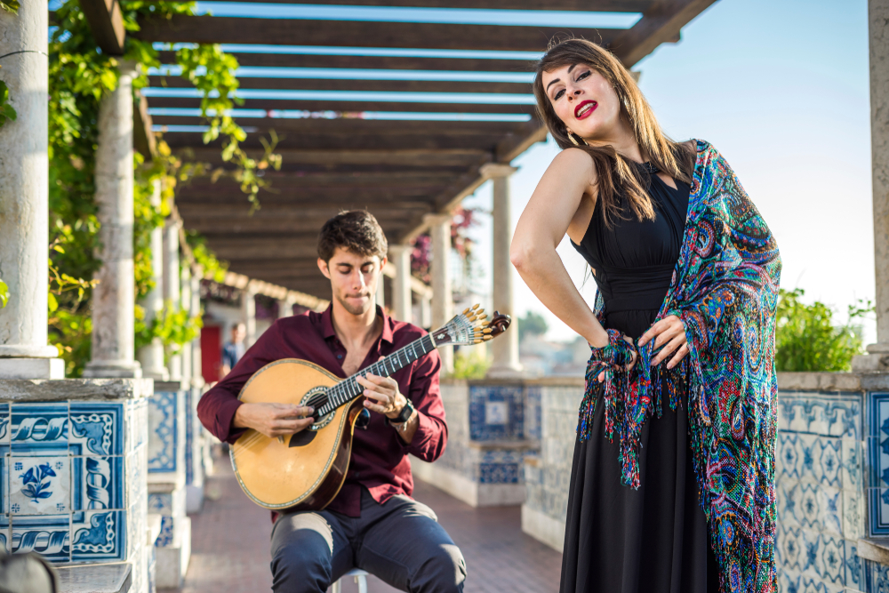 Guitarist and singer perform traditional music fado under pergola with Portuguese tiles called azulejos