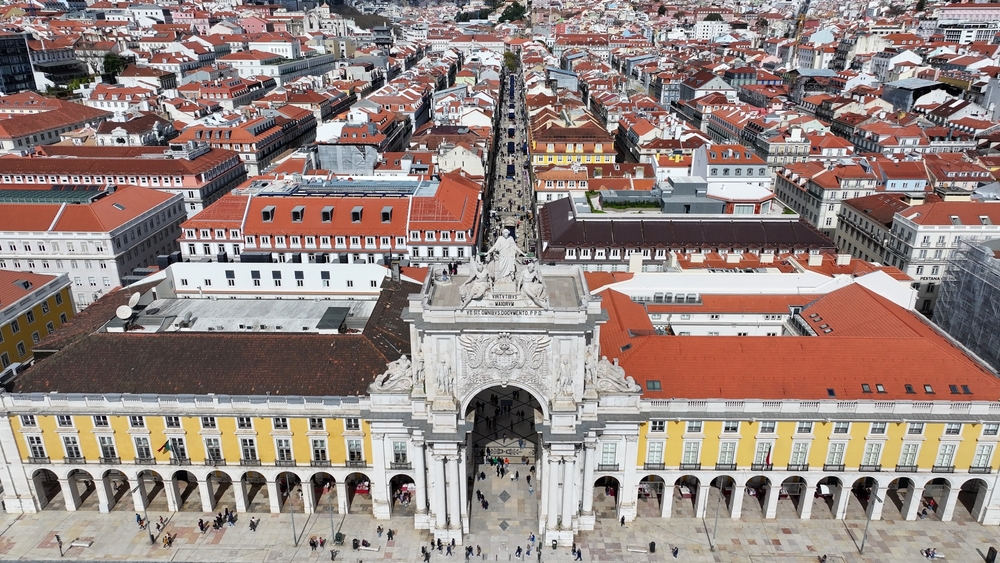 Lisbon's iconic Rua Augusta Arch stands over Praça do Comércio with the city beyond