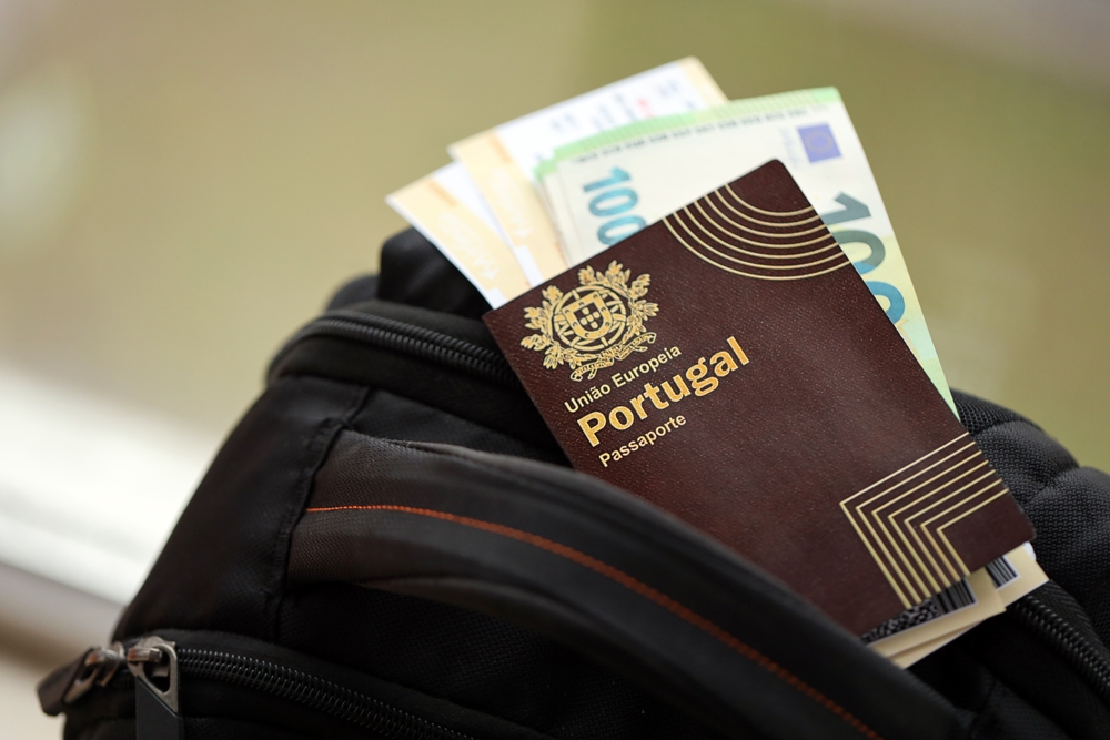 A Portuguese passport and Euro banknotes in a black backpack