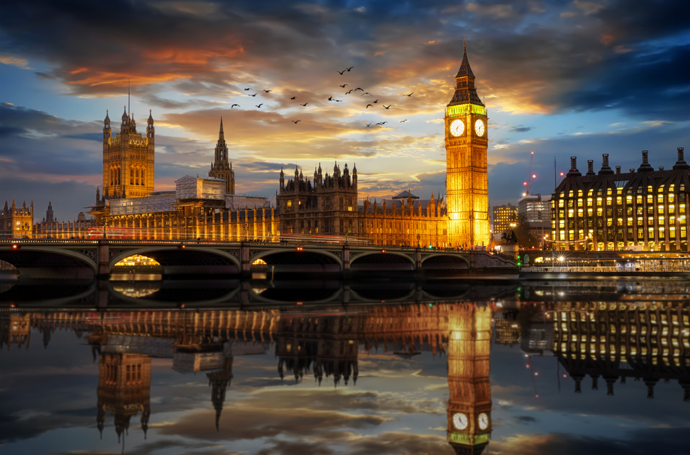 Westminster Palace and Big Ben clocktower by the River Thames in London at sunset
