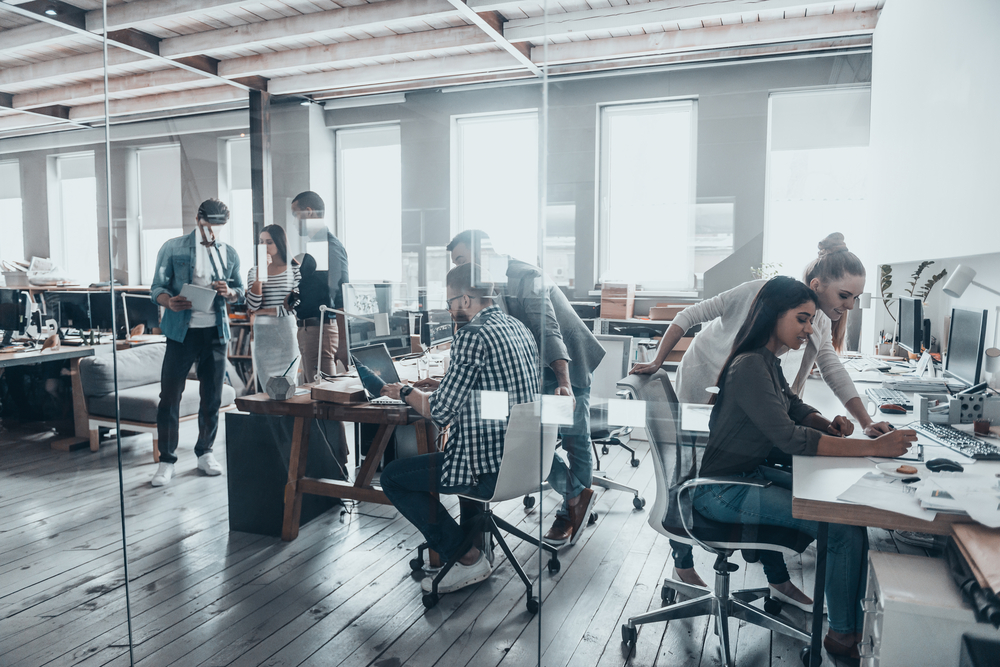 Group of young business people working and communicating together in office