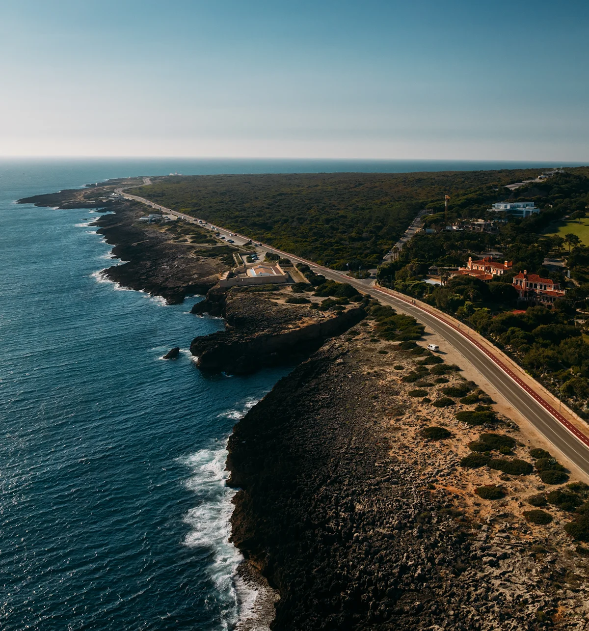 Rocky Cascais coastline with a road running along Quinta da Marinha cliffs and blue ocean