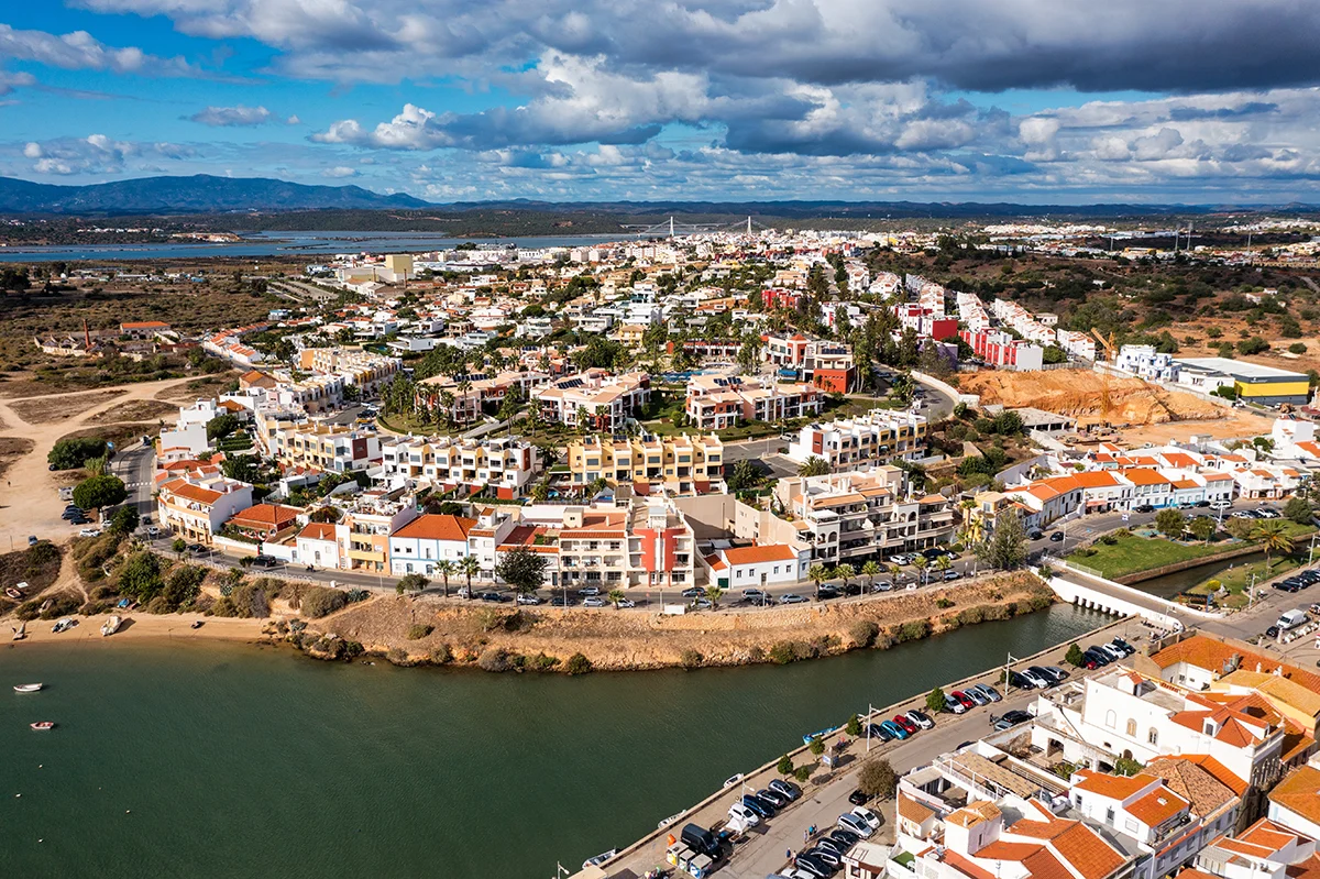 Colorful terracotta-roofed villas in Ferragudo along the scenic Arade River in Portugal