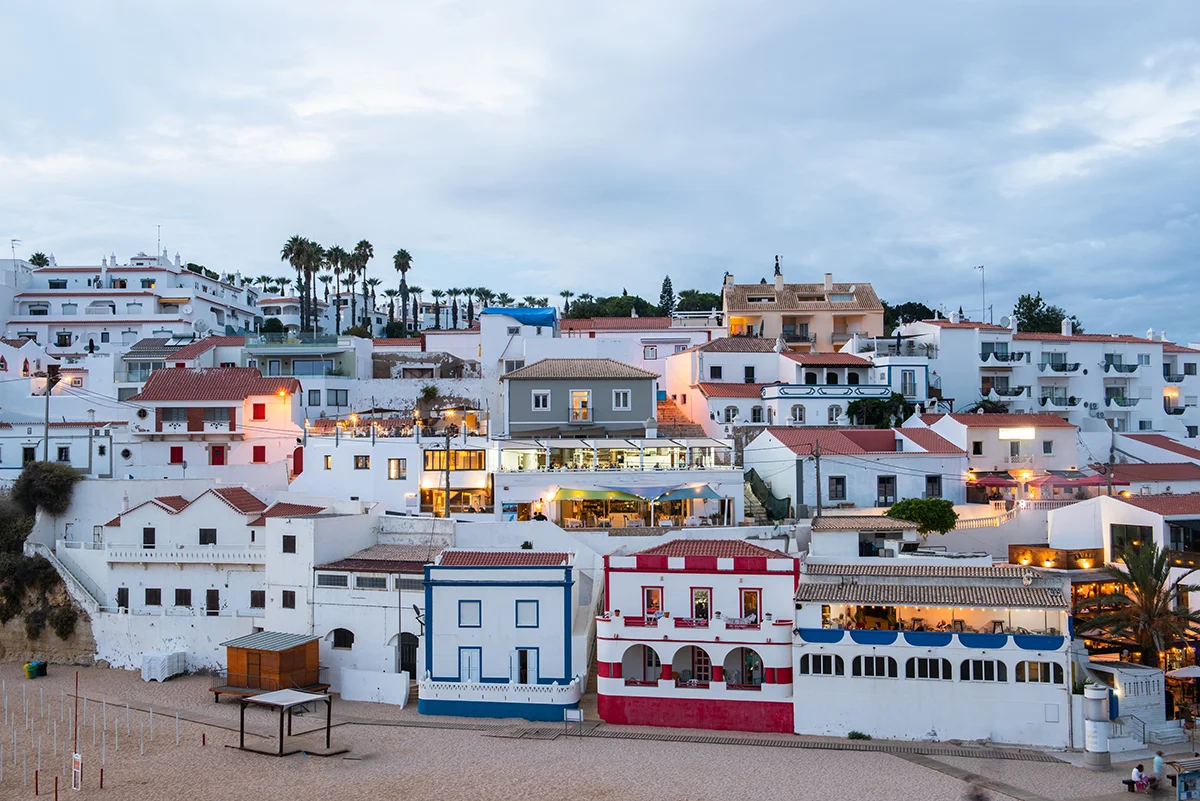 Colorful traditional Portuguese houses on the beach hills of Carvoeiro at twilight