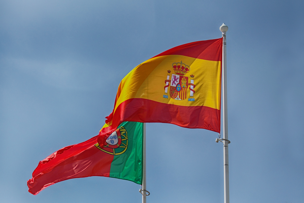 Portugal flag and spain flag with sky in the background