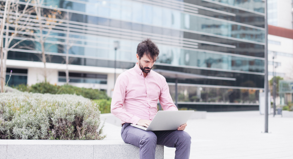 Entrepreneur working from laptop outside of business centre