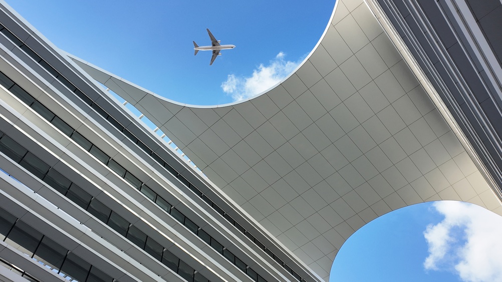 plane flying over modern business building in Portugal