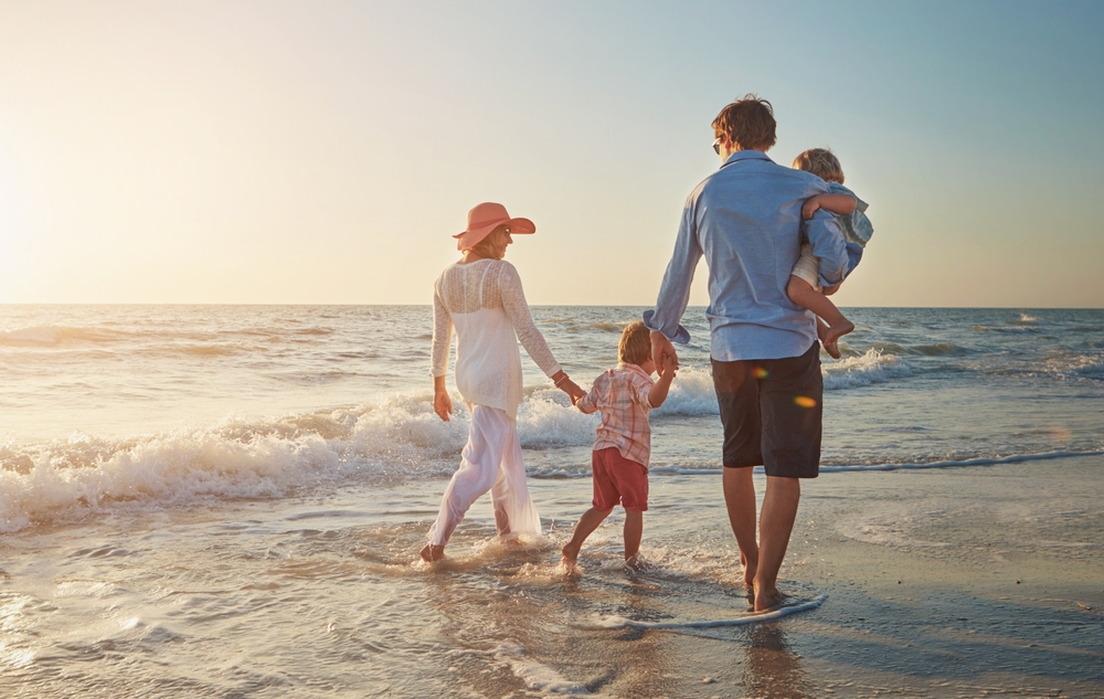Family walking along the beach in Portugal at sunset