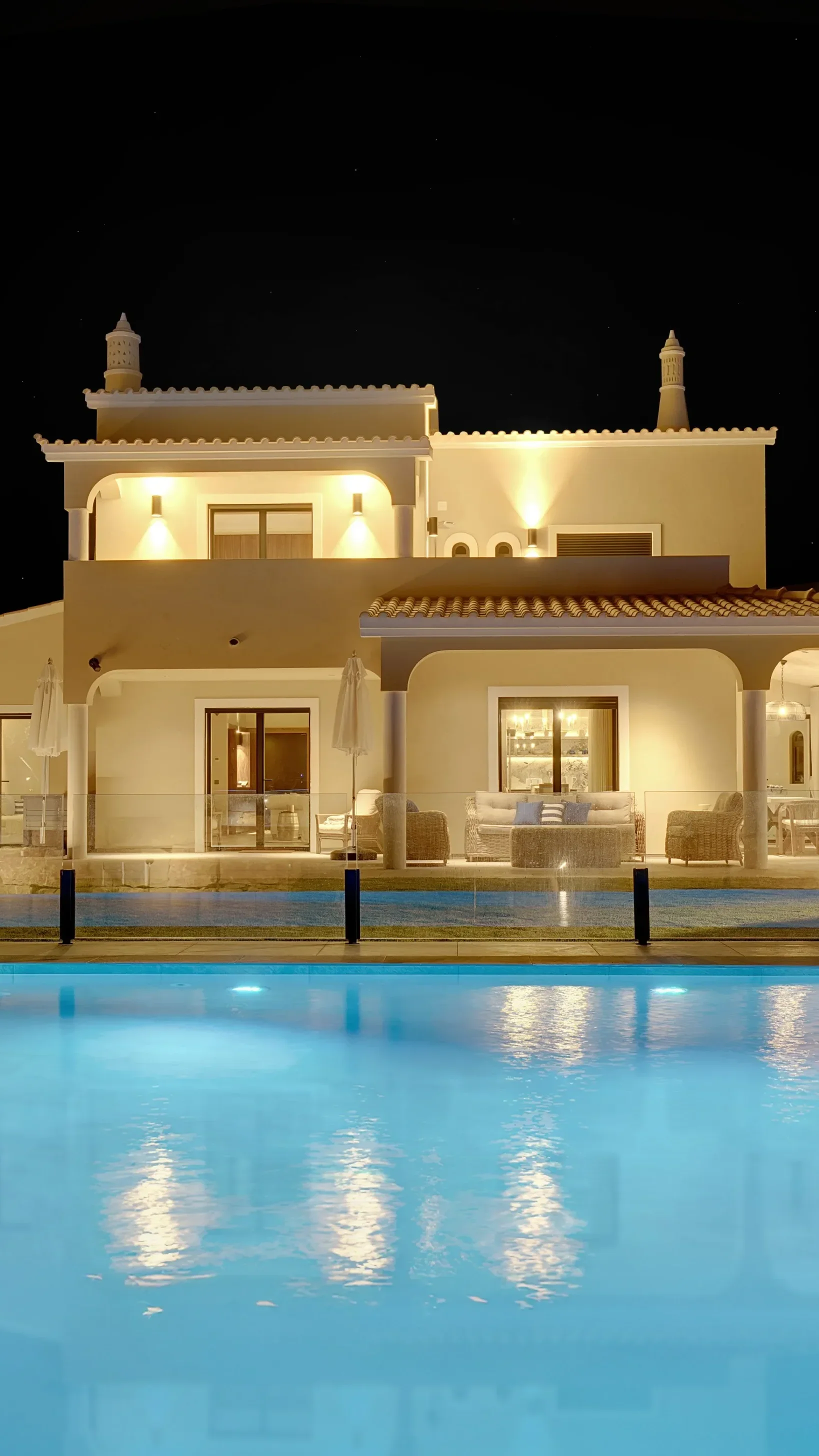 Villa Gale Short property exterior at night with illuminated pool and terrace.