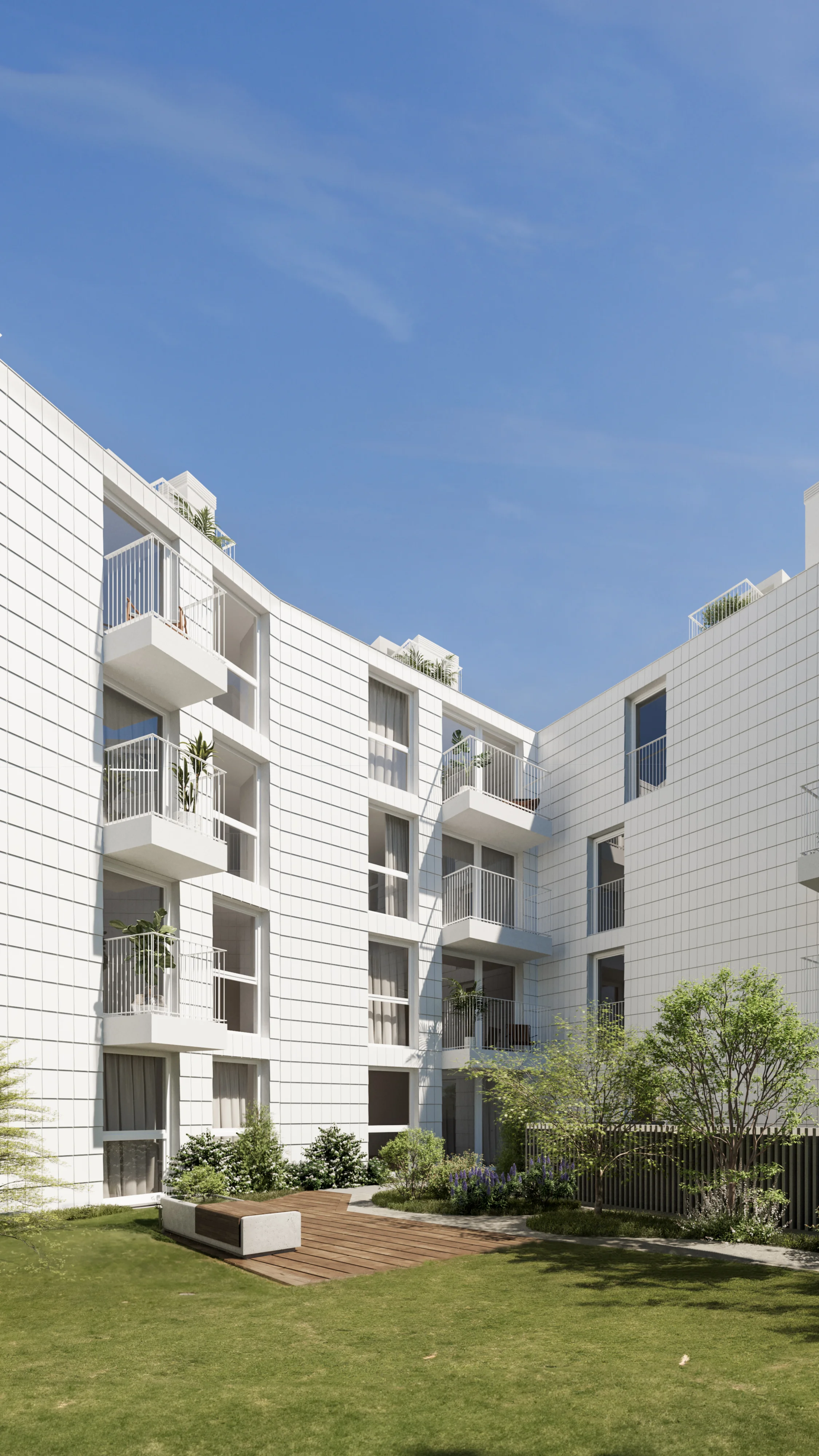 Modern white apartment building with balconies and a green courtyard in Portugal.