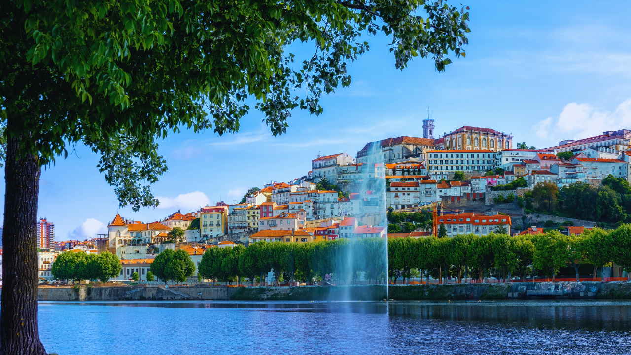 Scenic view of Central Portugal town and fountain with lush greenery.