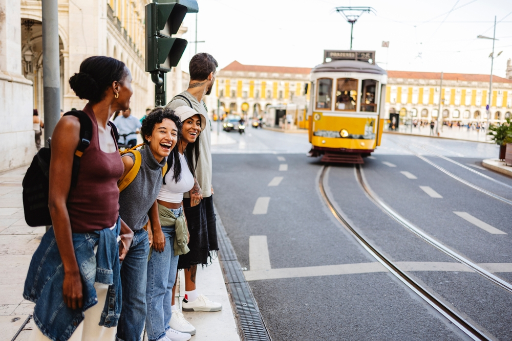 Group of tourists in Lisbon looking at a tram
