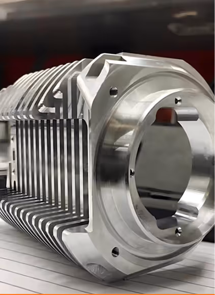 Close-up of a shiny, metallic engine cylinder block with cooling fins and bolt holes.
