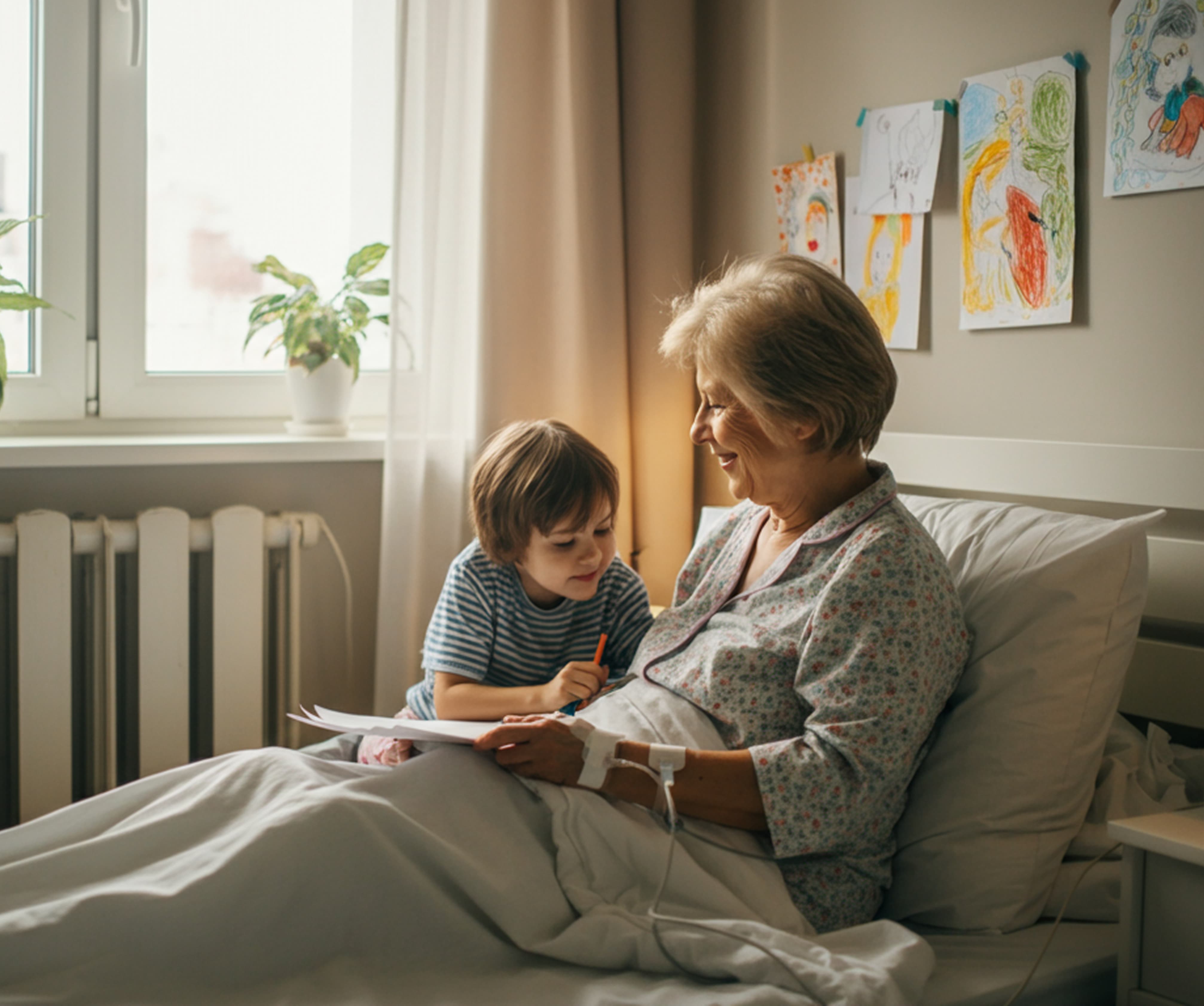 Smiling elderly woman in hospital bed with an IV, sharing a drawing moment with a young child.