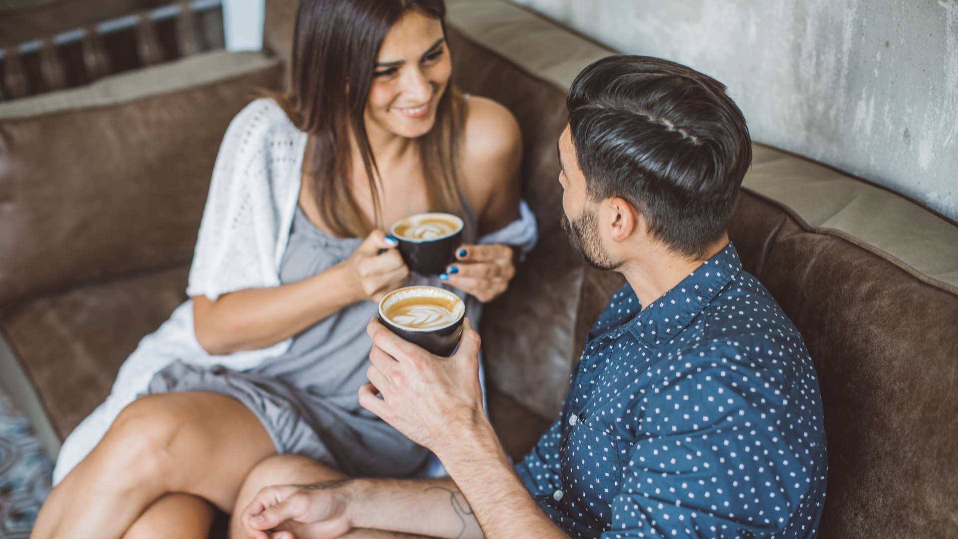 Couple drinking lattes on couch stock image