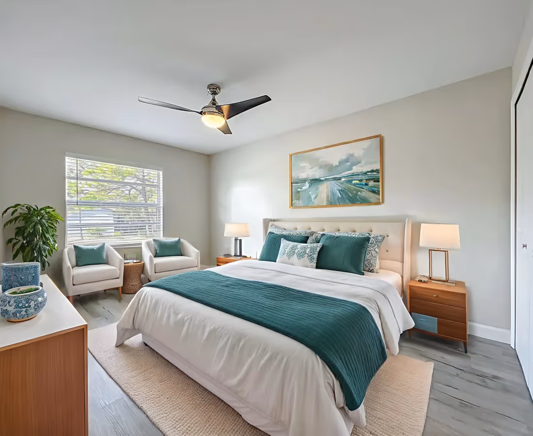 Bedroom featuring bed, chairs, lamps, ceiling fan, wall painting, and large window
