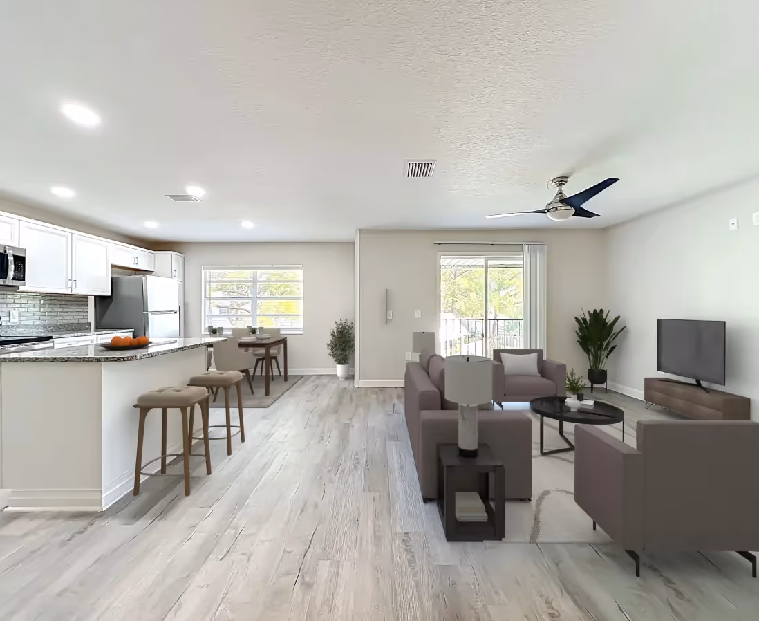 Living area with virtually staged sofa, coffee table, and chairs and view of kitchen island with chairs