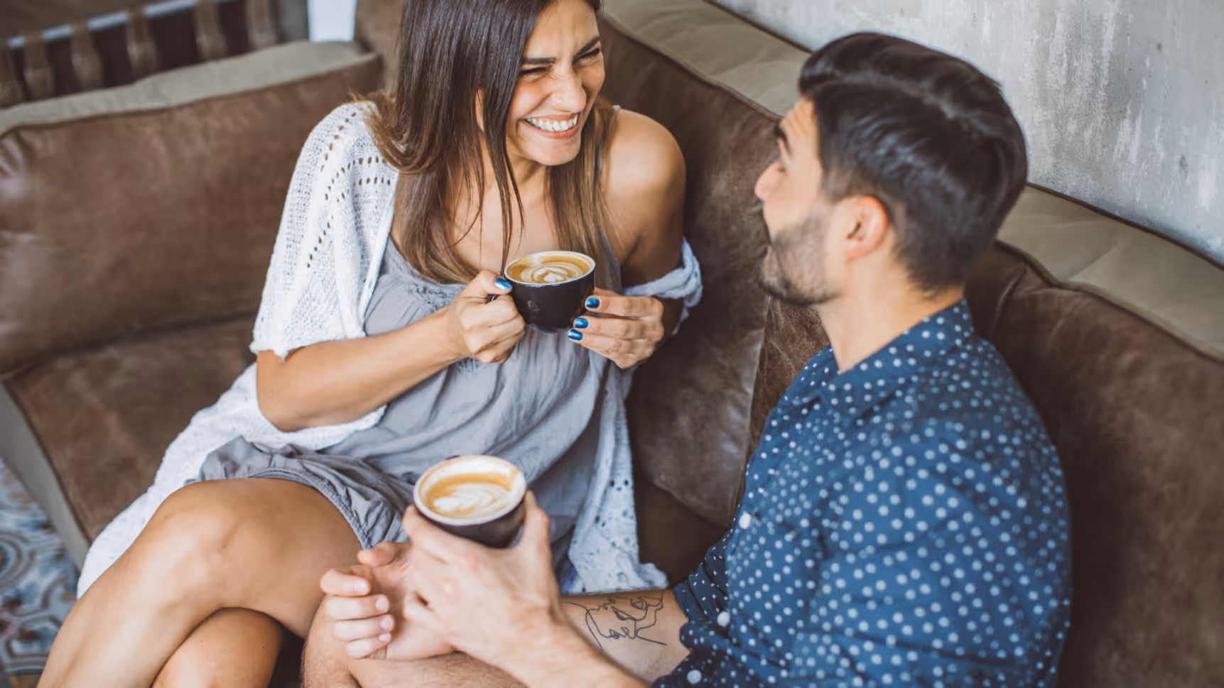 Couple sitting on sofa with drinks stock image