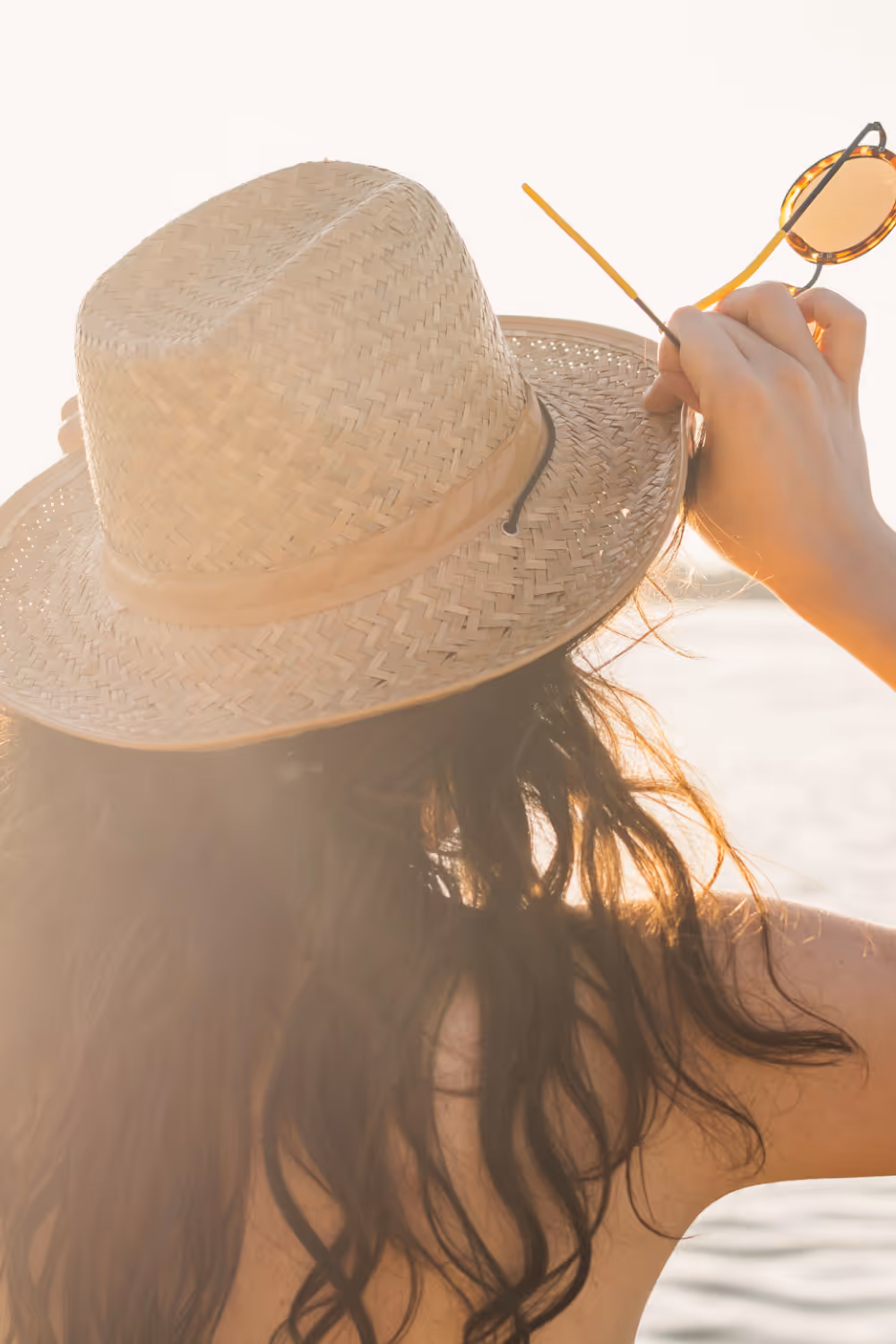 Woman with sun hat looking into sun stock image
