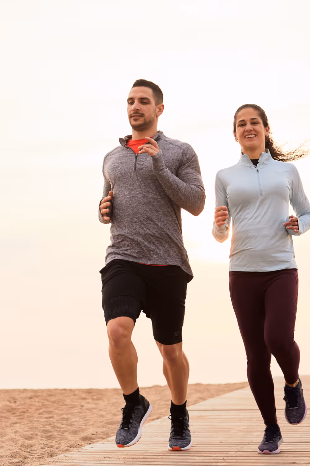 Woman and man running in active attire stock image