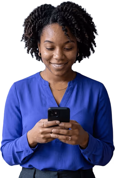 Smiling woman in blue blouse looking down and holding a smartphone with both hands.