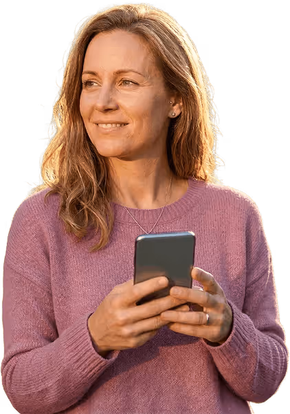 Smiling woman in a purple sweater holding a smartphone looking to the side.