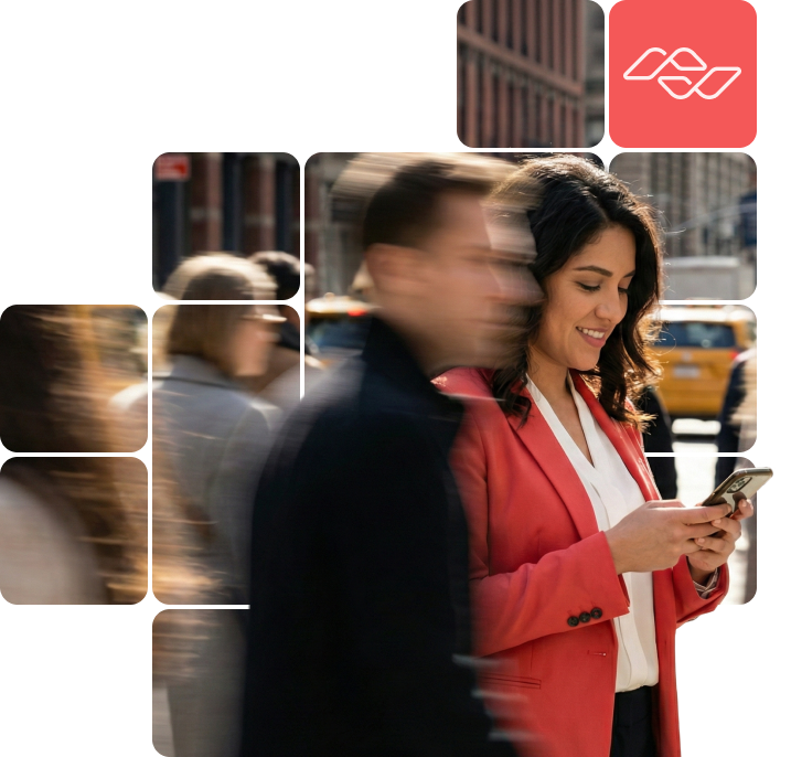 Woman in a red blazer smiling and using a smartphone on a busy city street