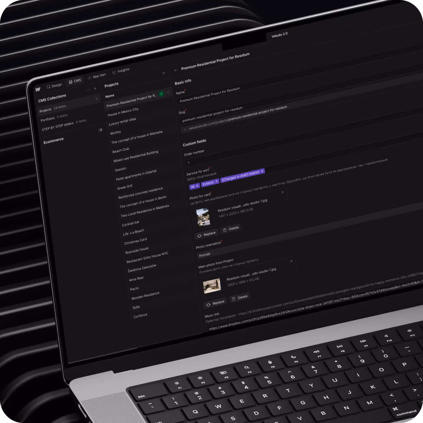 Ноутбук із відкритим інтерфейсом CMS Collections для керування проєктами нерухомості з двома мінімальними фотографіями.