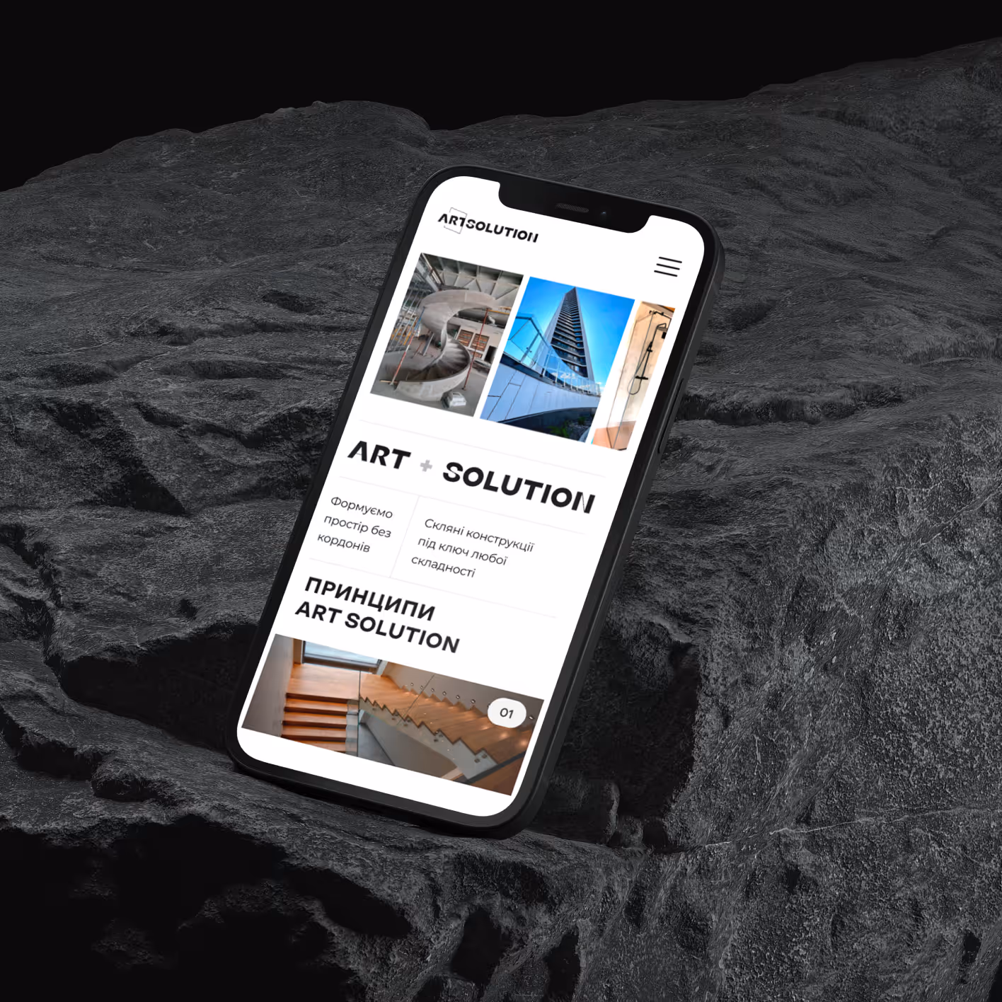 Смартфон на темному рельєфному фоні, екран якого показує вебсайт Art Solution про скляні конструкції і архітектурні рішення.