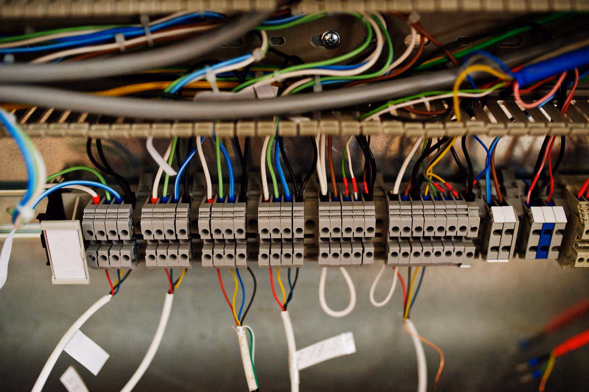 Close-up of an electrical panel with multiple colored wires connected to terminals.