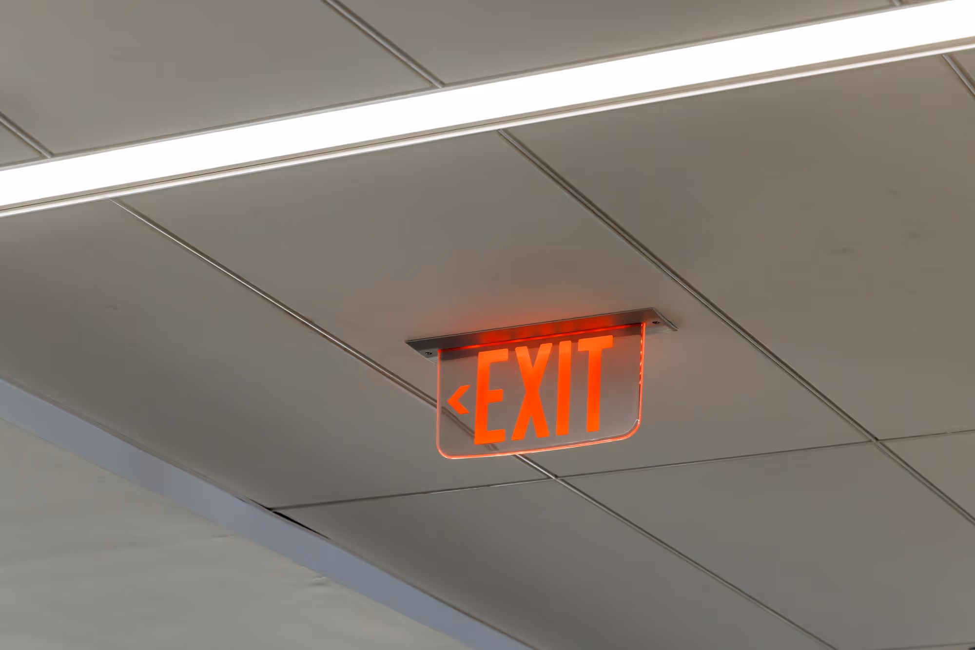 A red "EXIT" sign is illuminated on the ceiling.