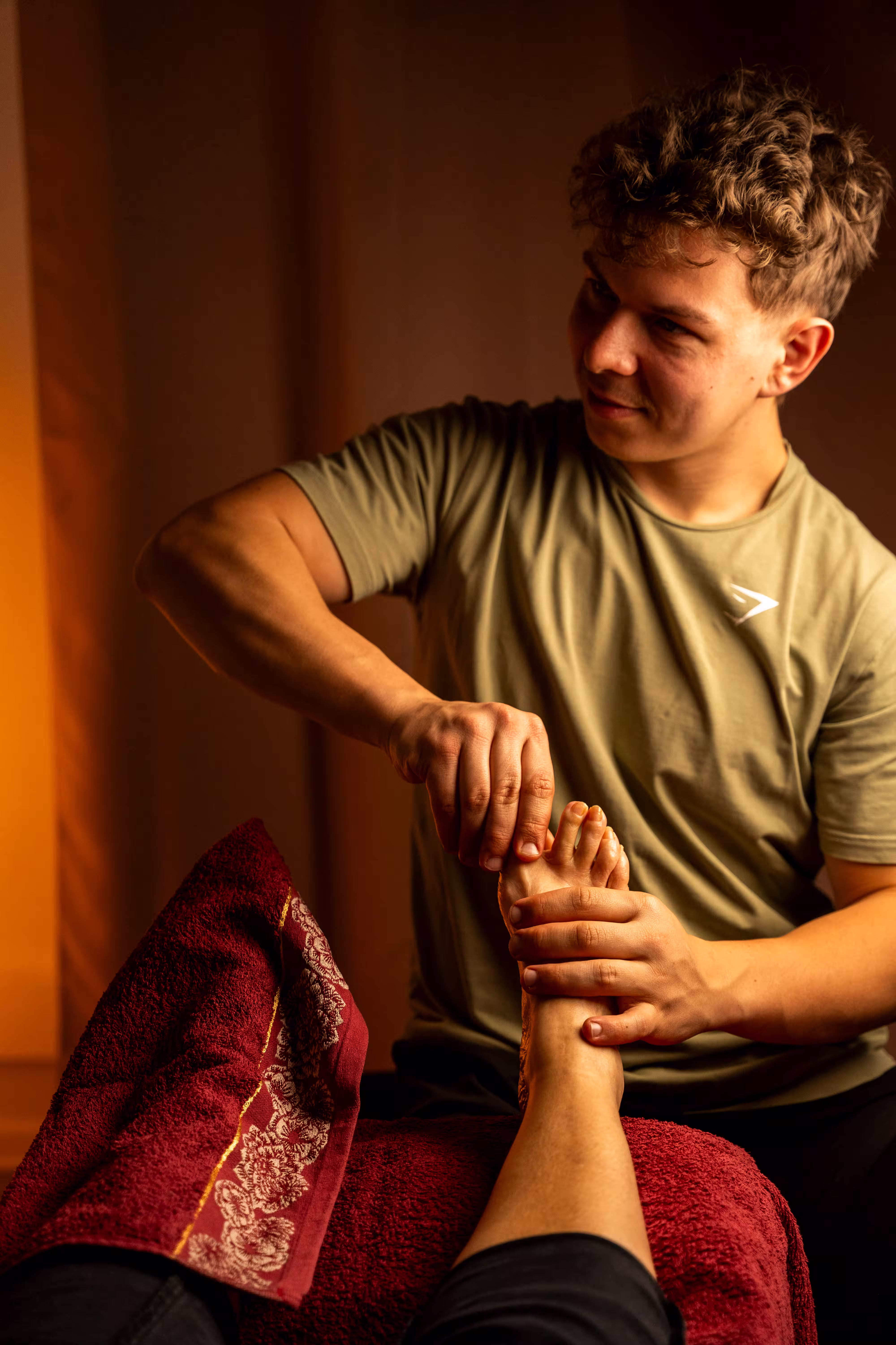 Masseur travaillant les zones réflexes sous le pied d'un client